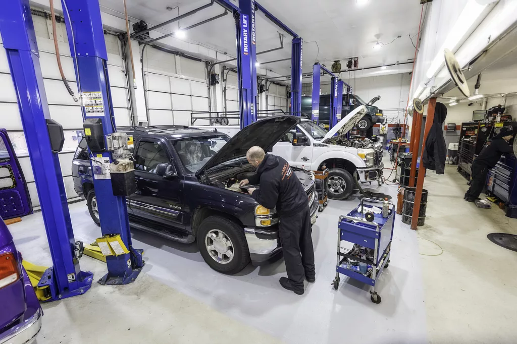 Ken's automotive and transmissions shop floor multiple lift bays truck open hood mechanic