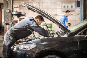 Car master auto mechanic repairer service technician checks and repairs the engine condition under the hood of the vehicle service shop