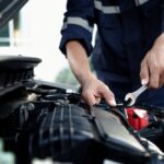 Mechanic using wrench to repair and maintain auto engine at car repair shop,Car auto services and maintenance check concept.