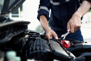 Mechanic using wrench to repair and maintain auto engine at car repair shop,Car auto services and maintenance check concept.